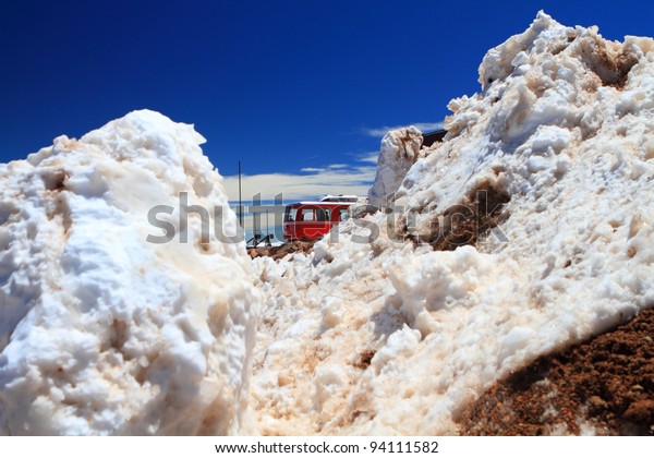 Winter scenery with piles of snow\
and a train on the top of Pikes Peak Mountain, Colorado,\
USA