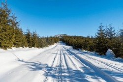 Winter Scenery With Snow Covered Road, Trees Around, Hill On The Background And Clear Sky Bellow Zielony Kopiec Hill In Beskid Slaski Mountains In Poland