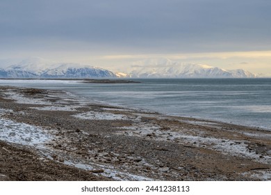 Winter seascape. View of the icy seashore. Mountains in the distance. Cold frosty winter weather. Sea of Okhotsk, Magadan region, Russian Far East. - Powered by Shutterstock