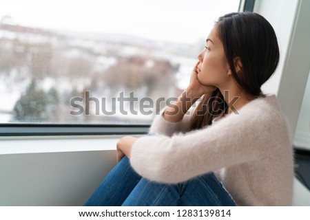 Winter seasonal affective disorder SAD depression mood alone Asian girl feeling lonely - stress, anxiety, melancholy emotions. Sadness at home.