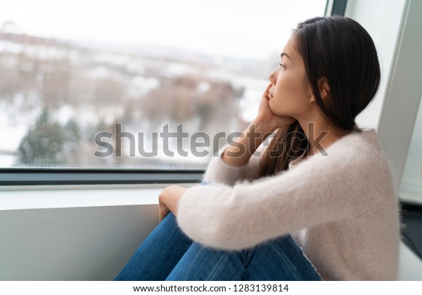 Winter seasonal affective disorder SAD depression\
mood alone Asian girl feeling lonely - stress, anxiety, melancholy\
emotions. Sadness at\
home.