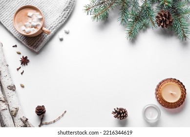 Winter seasonal concept. Christmas fir branches, pine cones, candles and hot coffee drink isolated on white background. Trendy flat lay, top view, copy space. - Shutterstock ID 2216344619