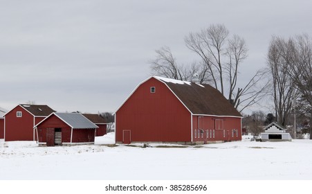 Winter Setting With A Red Barn And Farm