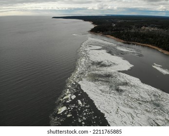 Winter Shore Lake Or River With Stones. Frozen Water With Ice And Snow. Aerial Drone View. Flying Over. View From Top Down. 