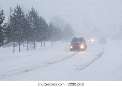 Winter, Snow, Blizzard, Poor Visibility On The Road. Car During A Blizzard On The Road With The Headlights.

