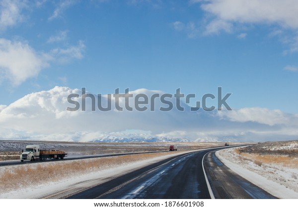 Winter snow highway among mountains.\
Trucks and cars are on a road. Utah, USA,\
12-12-2019