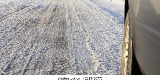 Winter Snow Road On Car Wheel Background. Winter Driving Safety On A Slippery Surface