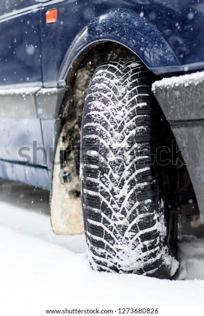 Winter is snowing. car wheel winter tires.\
close-up. have toning.
