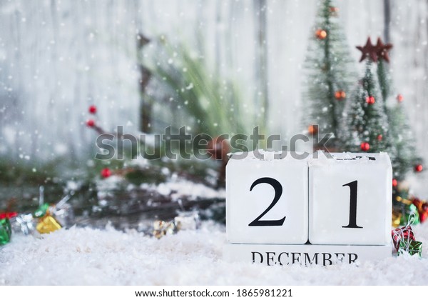 Winter Solstice. White wood calendar blocks
with the date December 21st and Christmas decorations with snow.
Selective focus with blurred background.
