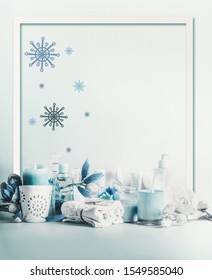 Winter Spa And Wellness Concept. Winter Skin And Body Care. Cosmetic Products. Holiday Spa Day. Frame. Blue Composition Of Candles, Towels, And Flowers. Winter Beauty 