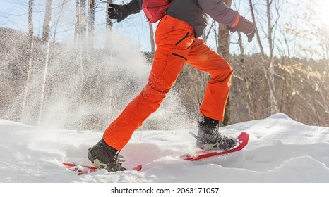 Winter sport outdoor exercise man running in snow in snowshoes having fun. Panoramic banner of snowing outside.