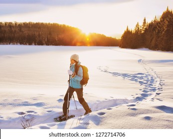 Winter Sport Woman Hiking In Snowshoes. Snowshoeing Girl In The Snow With Shoe Equipment For Outdoor Walking In Forest Trail. Quebec, Canada.