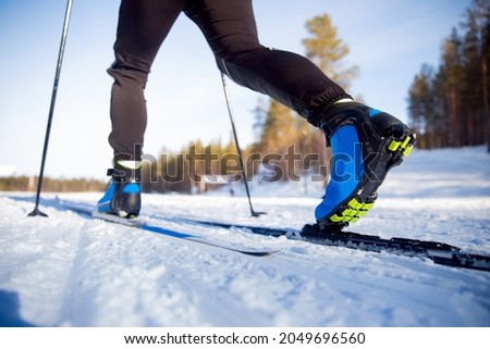 Winter sports competitions, boots and sticks cross of country skis glide on fresh snow.