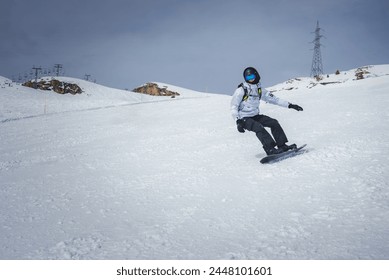 Winter sports enthusiast snowboarding down a snowy slope at a developed ski resort with a ski lift in the background, showcasing the thrill of the sport. - Powered by Shutterstock