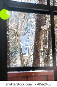 Winter Sports At Ski Lodge Looking Through The Window At The Ski Lift Taking Riders Up The Slopes For A Wonderful Day On The Snow