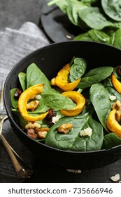 Winter Squash Salad With Spinach Served In A Black Bowl