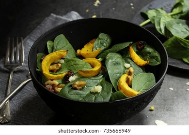 Winter Squash Salad With Spinach Served In A Black Bowl