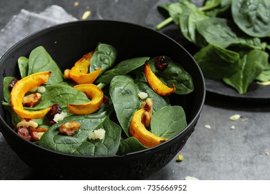 Winter Squash Salad With Spinach Served In A Black Bowl