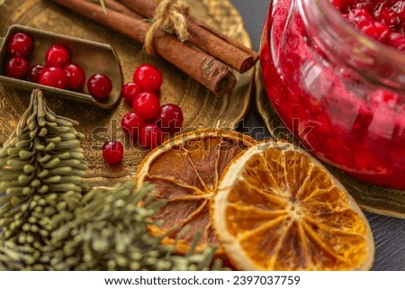 Winter still life with fresh red berries, lingonberries, dried oranges, cinnamon sticks, fir branches. Winter food 