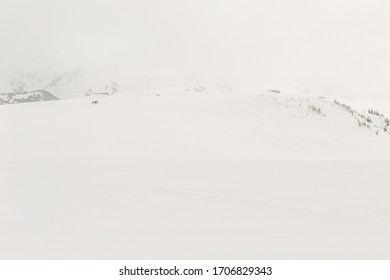 As a winter storm descends on the surrounding peaks, backcountry skiers, skin into Garibaldi Provincial Park from the Flute summit area of Whistler Mountain in BC's Coast Mountain Range. - Powered by Shutterstock