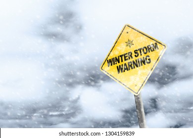 Winter Storm Season With Snowflake Symbol Sign Against A Snowy Background And Copy Space. Snow Splattered And Angled Sign Adds To The Drama.