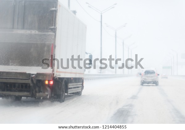 Winter Storm Traffic.\
Highway During Snow Storm. Heavy Snowfall and Heavy Traffic. truck\
or lorry on the road