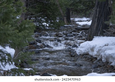 Winter stream flowing past banks of snow - Powered by Shutterstock