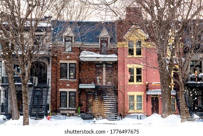 Winter street in Montreal, with traditional style architecture, snow covered balconies and heavy snowfall. Winter or Christmas themed seasonl image. 
