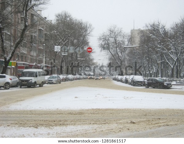 winter street, it\'s snowing, cars are moving\
along the snow-covered avenue, there are trees and cars in the snow\
                             \
