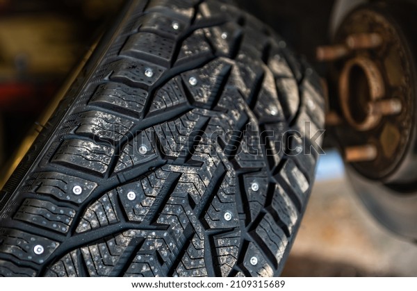winter studded tires in the service near the car,\
seasonal tire change,\
closeup