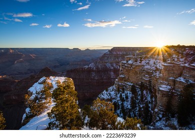 Winter Sunrise At Grand Canyon Arizona With Snow On The Cliffs And The Sun Peaking Above The Canyon Rim	