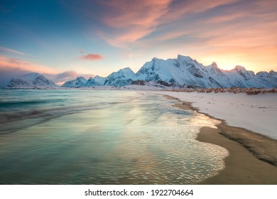 Winter sunset over the sea and mountains, colorful northern sunrise and sunlight in pink clouds. Lofoten Islands, Norway, Europe
