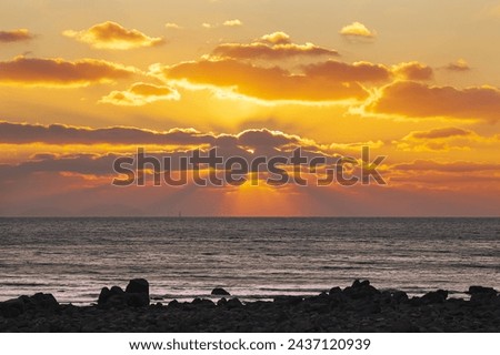 Winter and sunset view of seaside rock against sea horizon at Seonnyeobawi Beach of Eulwang-ri near Yongyu Island of Jung-gu, Incheon, South Korea
