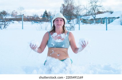 Winter Swimming. 50 Year Old Woman On The Snow Of A Frozen Lake. Recovery And Extreme Hardening On Ice Snow. Hardening And Youth.