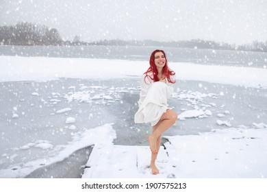 Winter Swimming And Cold Water Immersion. Pretty Cheerful Woman Wrapped In A Towel Is Hardening Outdoors On Snow At Icy Frozen Lake Landscape