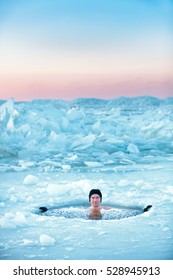 Winter Swimming In Frozen Sea. Man In An Ice-hole. Healthy Lifestyle