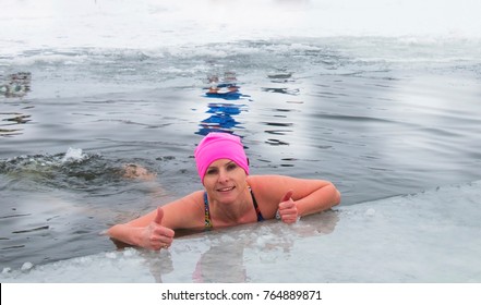 Winter swimming, a woman with pleasure swims in winter in the ic