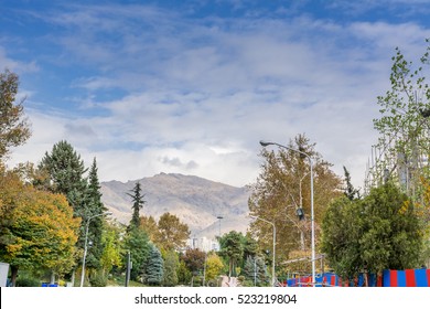 Winter Tehran Street View In Tehran International Exhibition Center With Snow Covered Alborz Mountains Against Cloudy Sky On Background