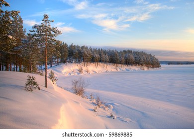 Winter time in forest lake. Evergreen wood and shore in snow - Powered by Shutterstock