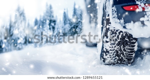 Winter tire banner or panorama detail in\
white snow. Car tires in snowy\
background..