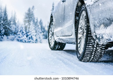 Winter tire. Car on snow road. Tires on snowy highway detail.
