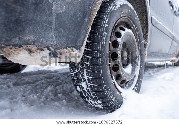 Winter tire. Car on snow road. Tires on snowy\
highway detail stock\
photo