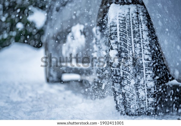 Winter tire. Detail of car tires in winter on the
road covered with snow.