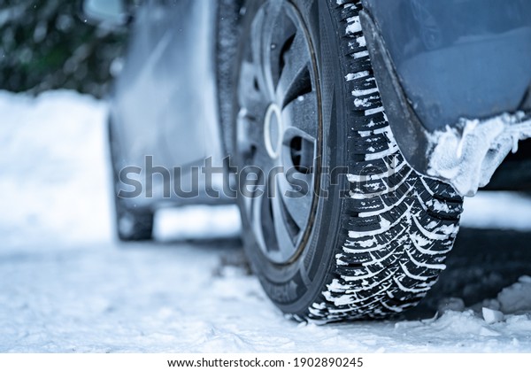Winter tire. Detail of car tires in winter on the\
road covered with snow.