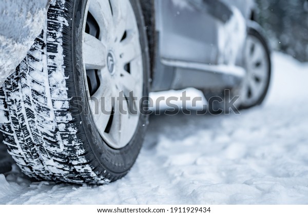 Winter tire. Detail of car tires in winter on the
road covered with snow.