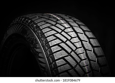 winter tire, friction for snow and ice. asymmetrical tread pattern. close-up on a black background. - Powered by Shutterstock