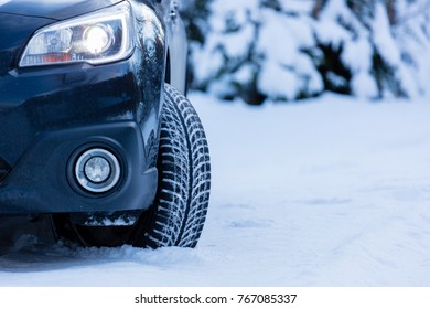 Winter tire. Front view of SUV car with headlights on. 