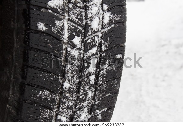 Winter tire on a snowy road. Detailed view of a\
sample of winter tires.