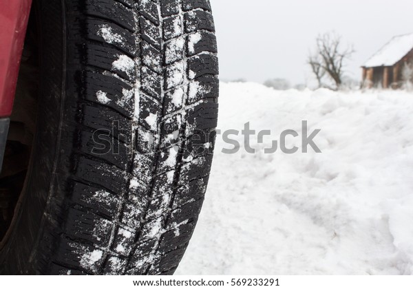 Winter tire on a snowy road. Detailed view of a\
sample of winter tires.