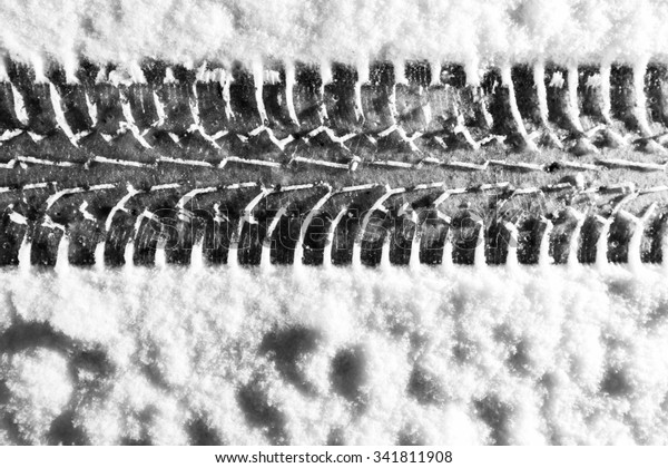 Winter tire print in the snow in Finland. Image\
includes a black and white\
effect.